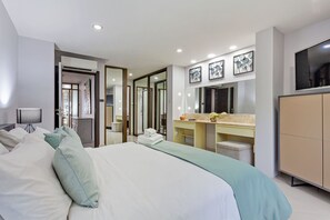 Een moderne hotelkamer met een groot bed, een kaptafel met spiegel en een televisie.