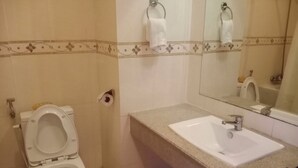 Un bagno con il water, lavandino e specchio.