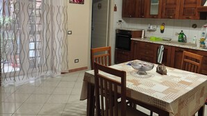 A dining area with a table, chairs, and a chandelier. - Cibali rooms (Catania)
