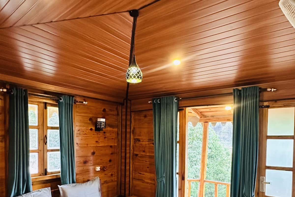 Une pièce en bois avec un lit, des rideaux et une fenêtre.
