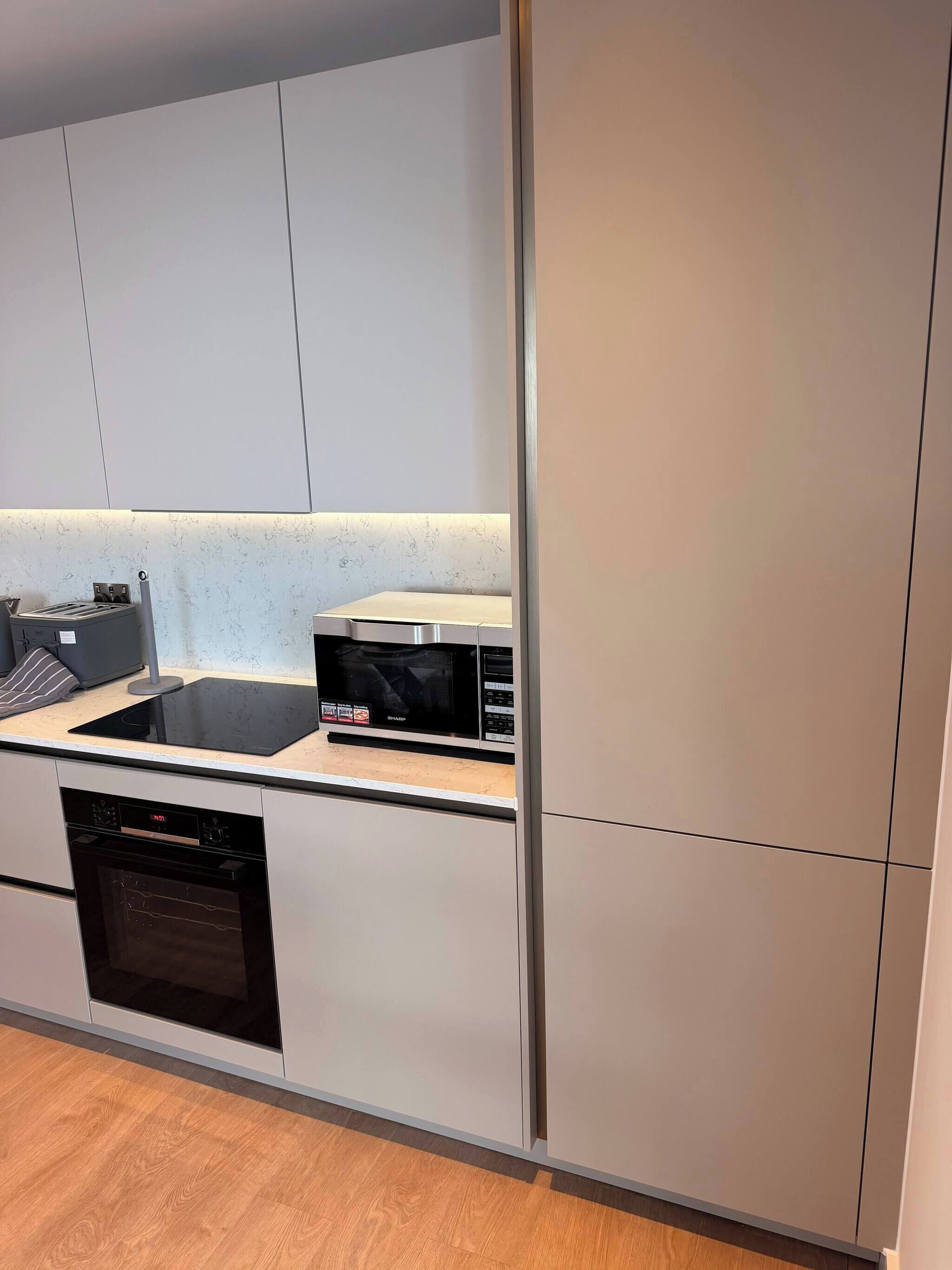 A modern kitchen with a built-in microwave, toaster, and dishwasher.