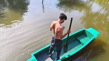 Uma pessoa em um barco pequeno sobre águas calmas.