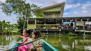 A green boat with two children on a calm river, a building with a balcony in the background. - Tranquility living in the garden ,20km from airport (ฉะเชิงเทรา)