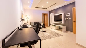 A modern living room with a flat-screen TV, a sofa, a dining table, and a ceiling with recessed lighting. - Sliema Bluemist near Balluta Bay (Sliema)