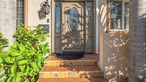 A building entrance with a number '138' above the door, a doormat, and a small tree in the foreground. - Beverly Hills Home • Guest House & Hot Tub (Beverly Hills)