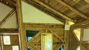 Un intérieur rustique avec des éléments en bois, comprenant un canapé, deux fauteuils et un petit pouf.
