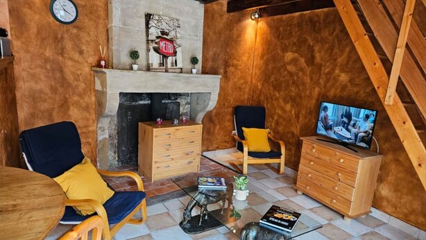 Una habitación acogedora con chimenea, muebles de madera, un televisor y una pequeña estatua.