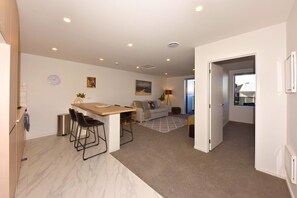 A modern apartment with a kitchen, dining area, and living room. - Chic and Comfy 1 Bedroom in Manchester Street (Christchurch)