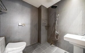 Une salle de bain moderne équipée d’une douche, de toilettes et d’un lavabo.