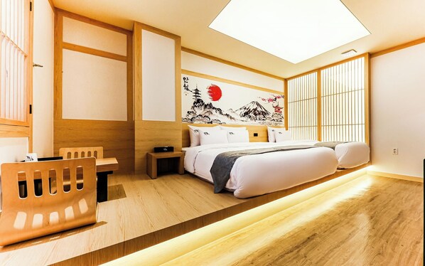 Une chambre d’hôtel moderne équipée d’un lit, d’une table de chevet et d’un bureau avec une chaise.