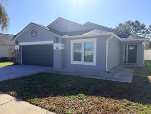 A residential house with a garage, a front door, and a driveway. - 4 Bedroom Villa close to Theme Parks sleeps 9 (Clermont)