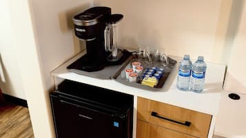 A compact kitchenette with a microwave, coffee maker, and a small refrigerator.