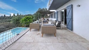Una terrazza sul tetto con piscina, mobili in vimini e vista sulla campagna.