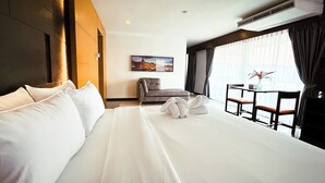 A hotel room with a large bed, a small table with chairs, a painting on the wall, and a window with curtains. - The Holiday Resort Pattaya (Pattaya)