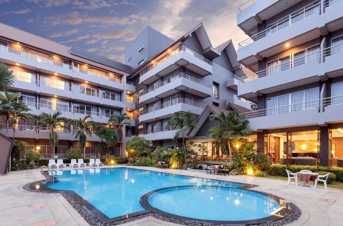 Um hotel com piscina, várias varandas e áreas de estar ao ar livre.