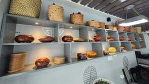 A room with shelves displaying various woven baskets and pottery. - The Gochuka Hotel (Thimphu)