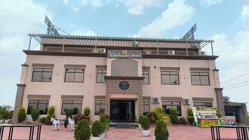 A building with a sign reading 'Vaishnavi Resort' and a sign for 'Vaishnavi Yoga & Wellness.'