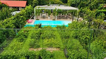 Ein Wohngebiet mit Schwimmbad, Garten und überdachter Terrasse.