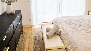 Un dormitorio con cama, mesita de noche y cómoda.