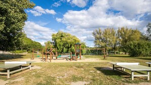 Un parc infantil amb cadira d'oscil·lació, tobogan i estructura per escalar.