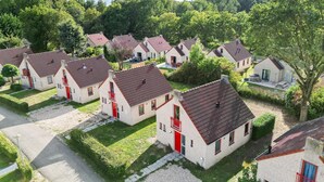 Zona residencial amb diverses cases, amb portes vermelles i teulades d'estil clàssic.