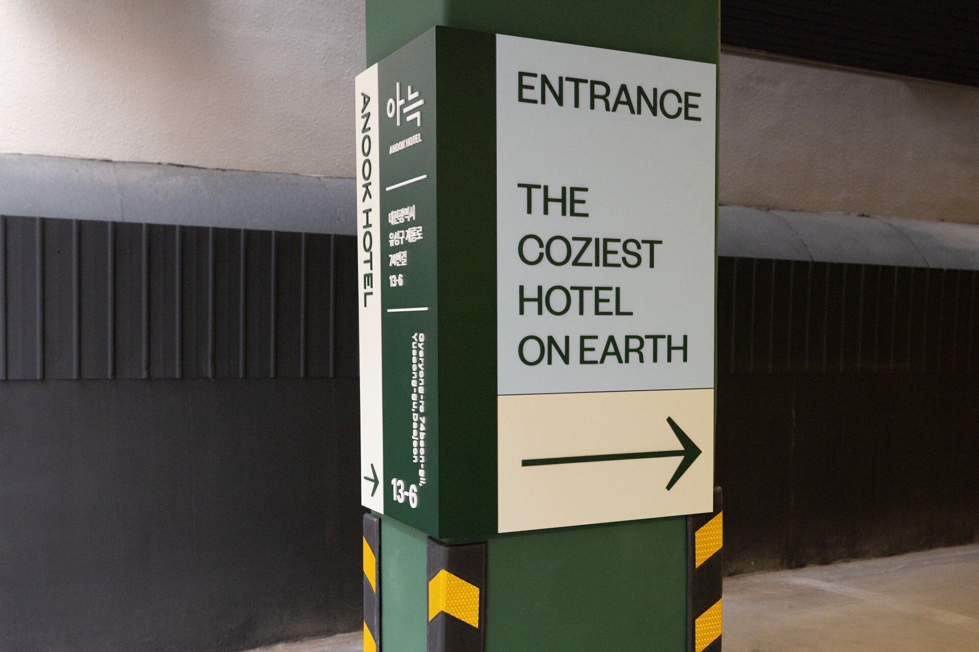 A sign indicating the entrance to The Coziest Hotel on Earth.