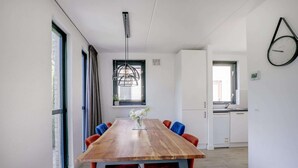 Une cuisine moderne avec des armoires blanches, un four encastré et une fenêtre.