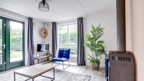 Ein modernes Wohnzimmer mit einer Couch, Fernseher und Kamin.