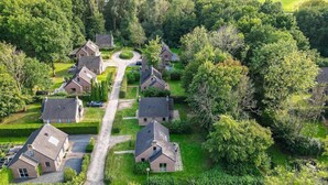 Un quartier résidentiel composé de maisons, d’une rue principale et d’espaces verts environnants.