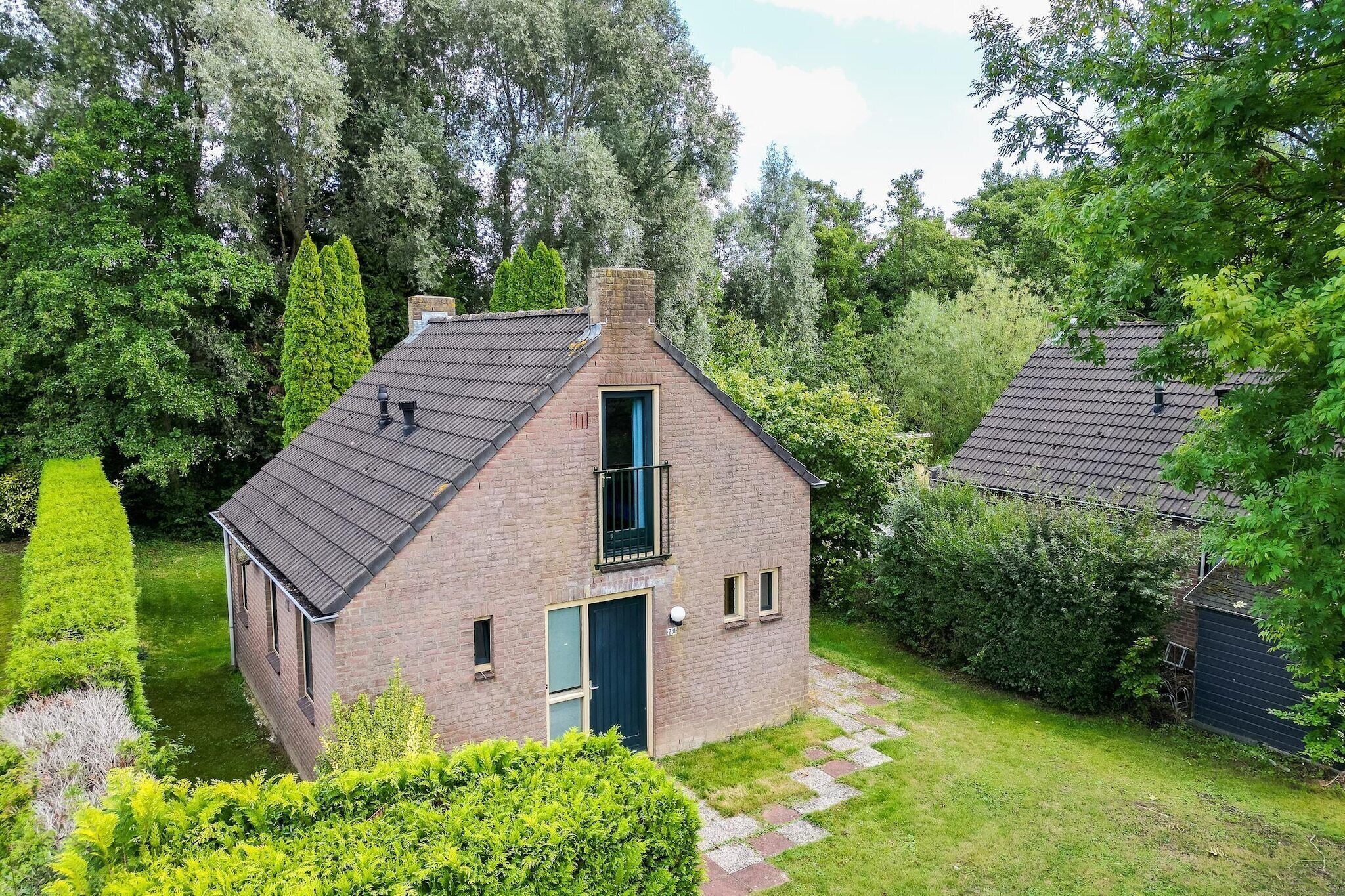 A small brick house with a sloped roof, a front door, and a visible chimney.