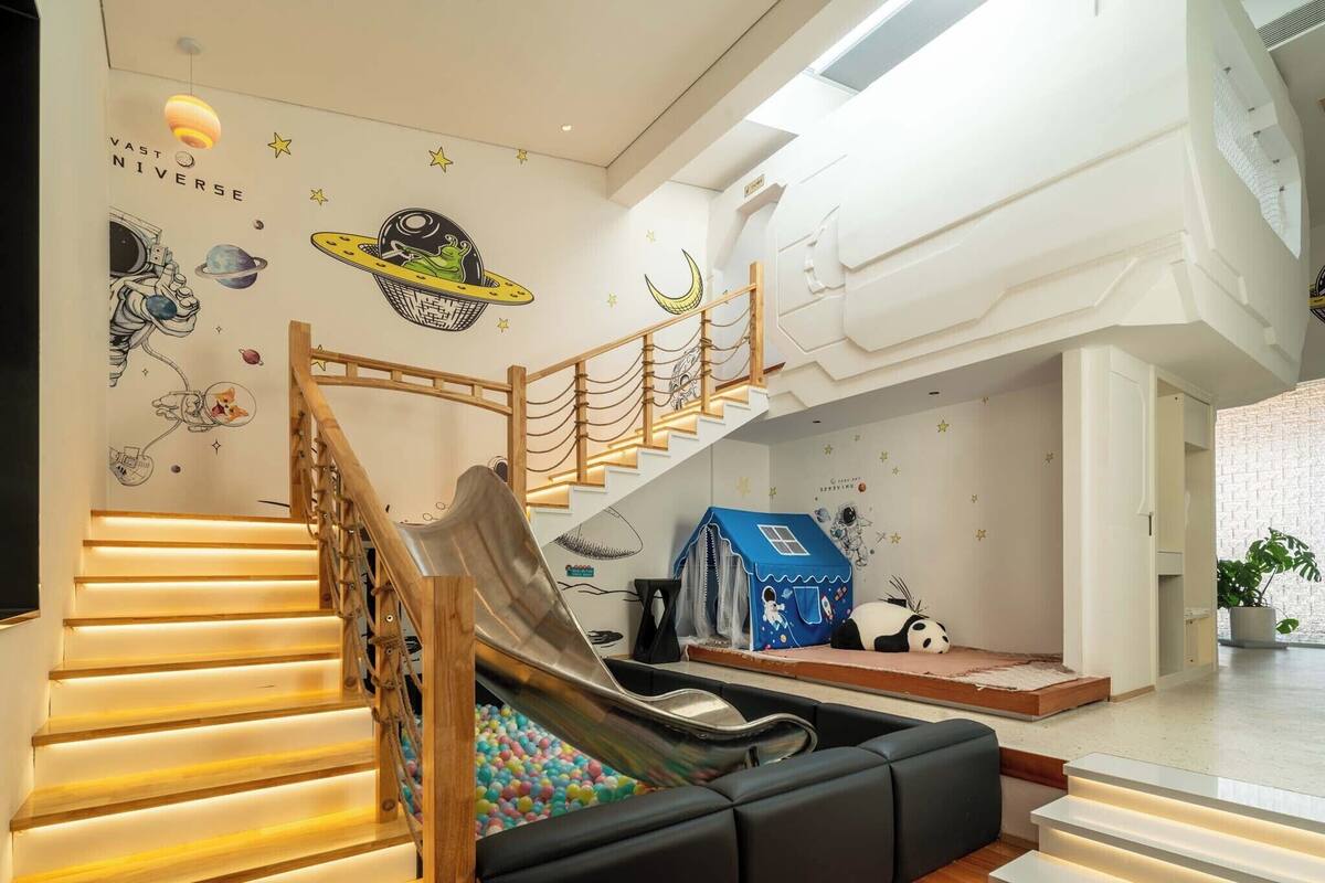 A play area with a slide, a ball pit, and a small blue house.