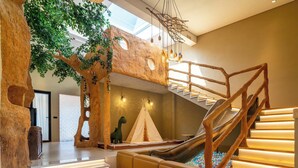 A multi-level play area with a slide, a tree structure, and a staircase. - Manning Retreat (Handan)