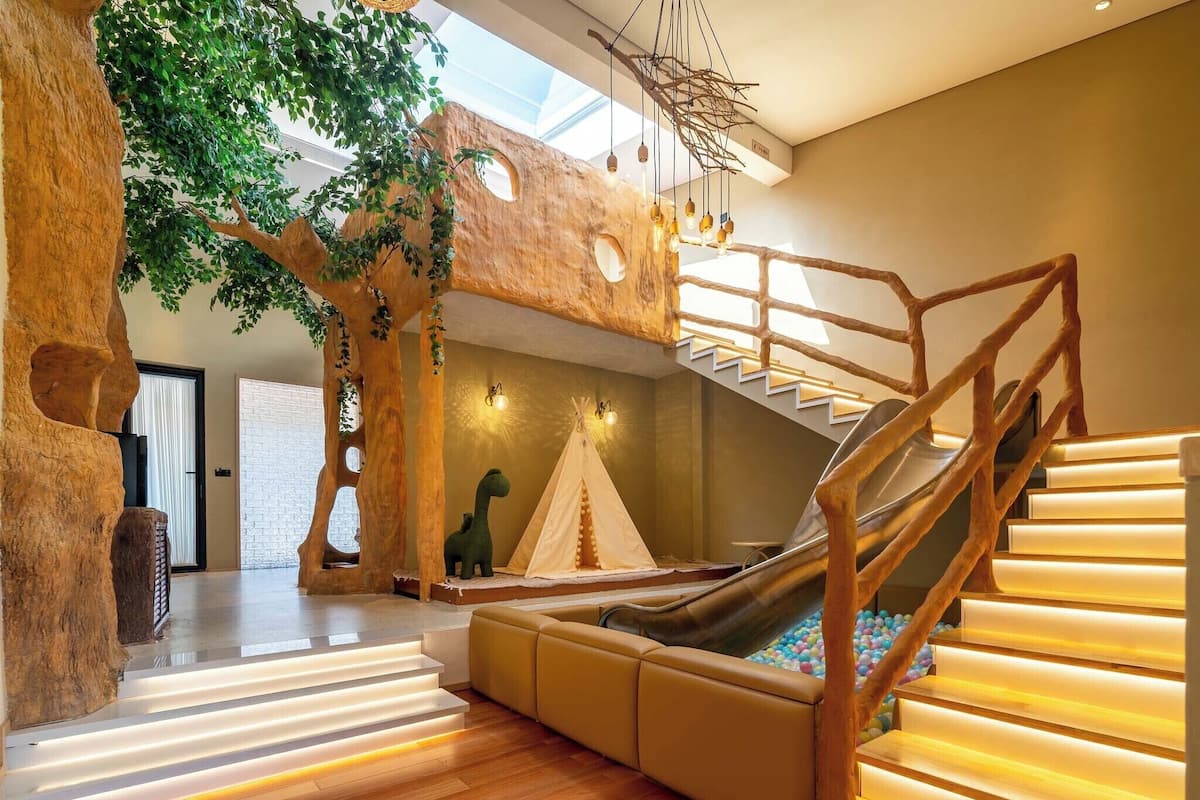 A multi-level play area with a slide, a tree structure, and a staircase.