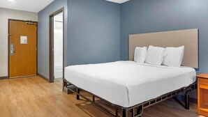 Ein Hotelzimmer mit einem Bett, einer Holztür und einem Nachttisch.