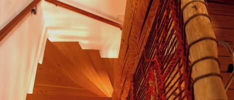 A wooden staircase with a handrail and a patterned fabric covering.