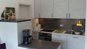 Eine moderne Küche mit grauen Schränken, einer Kaffeemaschine, einem Toaster und einer Spüle.