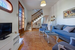 A living room with a TV, sofa, chairs, a staircase, and a dining area. - Elegant and welcoming 70 square meters townhouse, perfect for six people, with a private entrance and spread over two floors.The property is located in Villasimius, a town known for its splendid sandy beaches and crystal-clear sea. The apartment is centr (Villasimius)