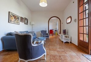 A living room with a sofa, armchairs, a TV, and artwork on the walls. - Elegant and welcoming 70 square meters townhouse, perfect for six people, with a private entrance and spread over two floors.The property is located in Villasimius, a town known for its splendid sandy beaches and crystal-clear sea. The apartment is centr (Villasimius)