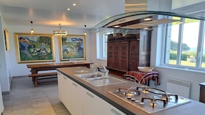 A modern kitchen with a central island, double sinks, and a large window. - Spacious Coastal Villa near Rospico Beach (Nevez)