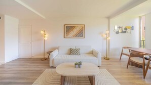 A living room with a sofa, coffee table, floor lamp, and a dining table. - Magnificent Appartment - 6P - Saint Tropez Center (Saint-Tropez)
