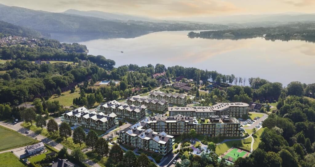 Un ensemble résidentiel comprenant plusieurs bâtiments, un lac et des espaces verts environnants.