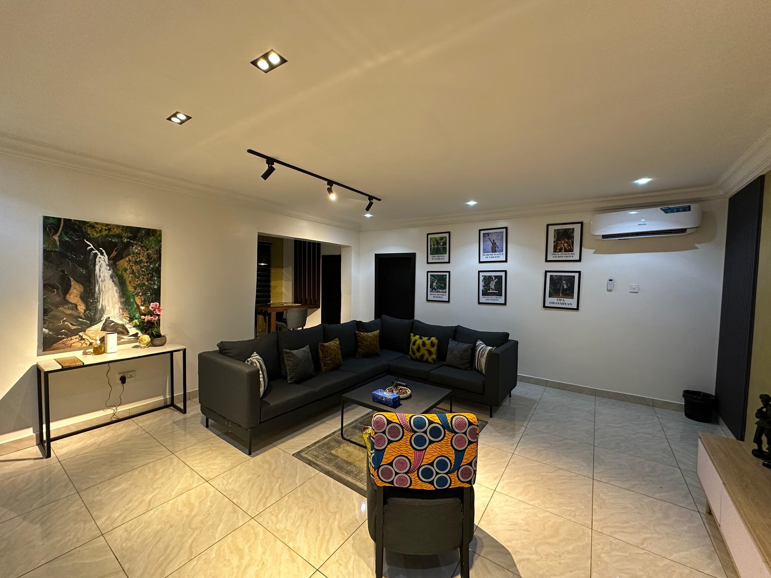 A modern living room with a sectional sofa, a coffee table, and a colorful chair.