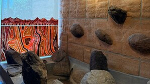 Une pièce avec un mur en pierre, un plafond en bois et une fenêtre donnant sur un beau paysage.