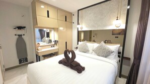 A hotel room with a bed, a mirror, a vanity, and a towel art on the bed. - A104- 1 Bedroom Serviced Apartment with Whirlpool at Ao Nang Beach (Tambon Ao Nang)