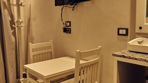 A room with a white table and chairs, a flat-screen TV mounted on the wall, and a small counter with a sink. - Town Hotel Hurghada (Hurghada)