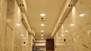 A marble-floored hallway with a bench, recessed ceiling lights, and a door at the end. - Town Hotel Hurghada (Hurghada)
