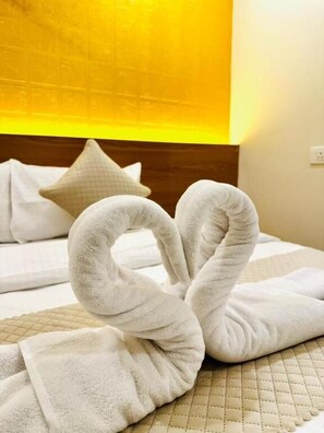 Ein Hotelzimmer mit einem Bett, Kissen und einer Wand mit einer Leuchte.