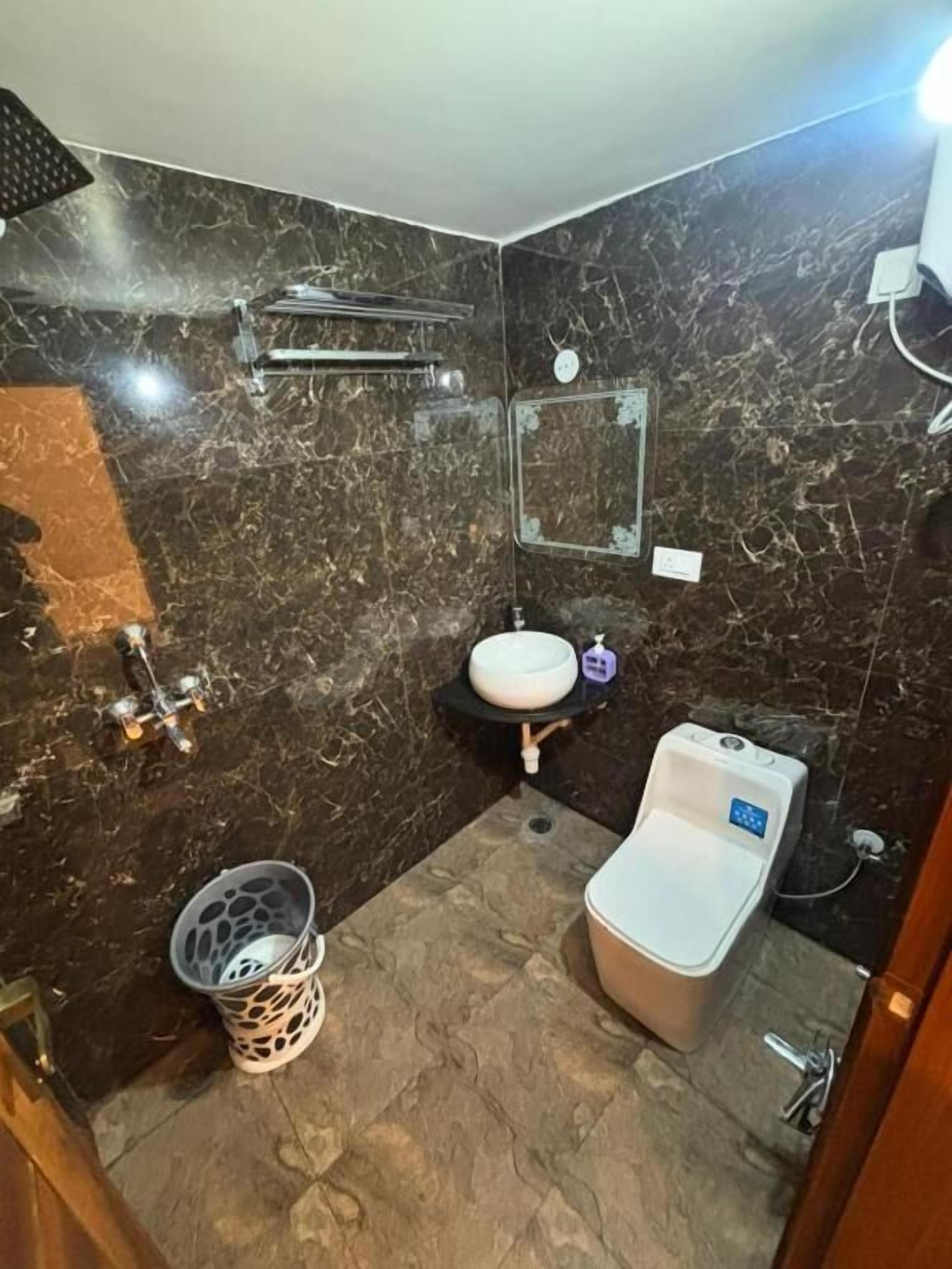 Ein Badezimmer mit Waschbecken, Spiegel, Dusche und Toilette.