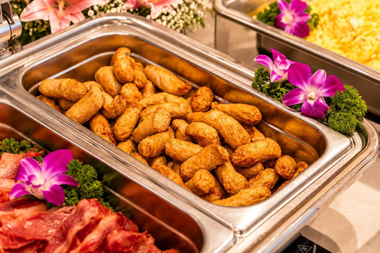 A buffet with various food items including fried snacks and meats.