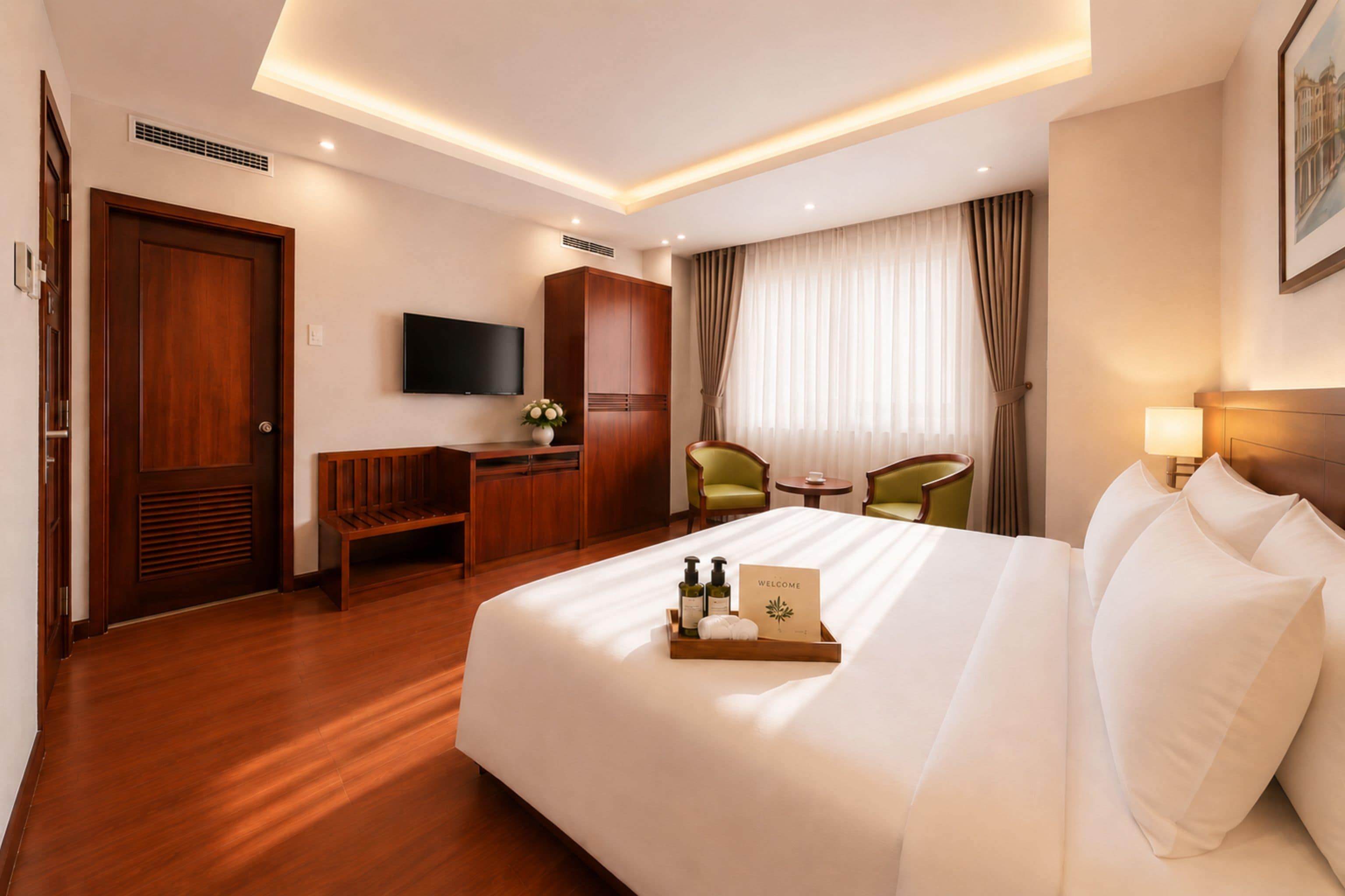 A hotel room with a bed, a desk, a chair, a television, and a window with curtains.